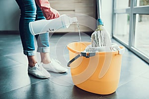 Woman in Gloves prepearing to Wipe Floor with Mop