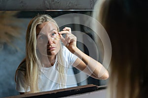 .woman glues sparkles on her face