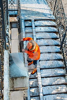 Woman goes down the slippery stairs. Winter in the city.