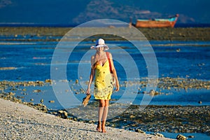 Woman goes for a walk at sundown on the beach