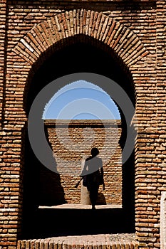 Woman going through the gateway in Alcazaba castle