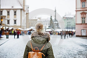 Woman is going to Christmas market during Advent holiday during snowfall