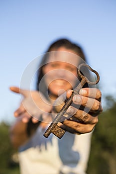 Woman gold key in hand blue sky