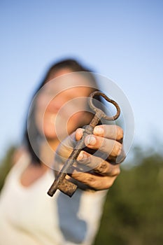 Woman gold key in hand blue sky