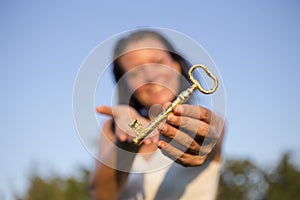 Woman gold key in hand blue sky