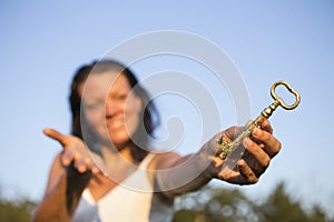 Woman gold key in hand blue sky