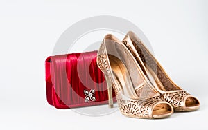 Woman gold shoes on background whit red purse