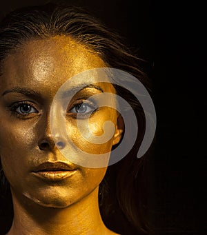 Woman with golden makeup and bodyart