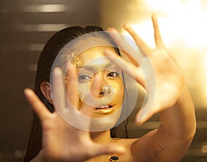 Woman with golden makeup and bodyart