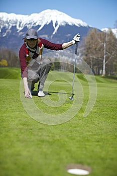 Woman golfer aligning golf ball