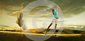 Woman golfer hitting the ball on the background scenery