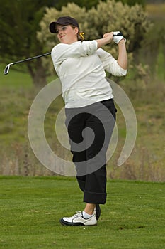 Woman golfer swinging club