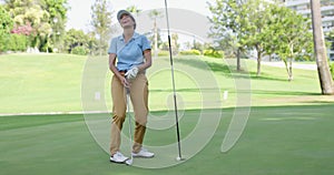 Woman golfer about to sink her putt