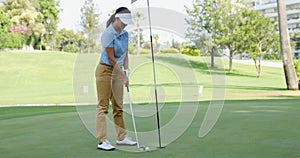 Woman golfer about to sink her putt