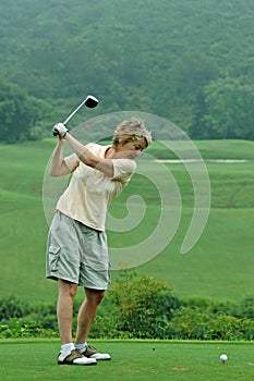 Woman golfer about to tee off/drive onto the fairway