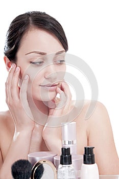 Woman with a good complexion near the creams cosmetics.