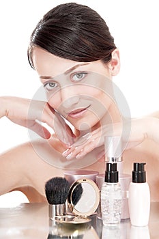 Woman with a good complexion near the creams cosmetics.