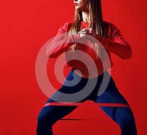 Woman with good physique doing stretching work out with elastic bands.