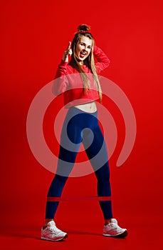 Woman with good physique doing stretching work out with elastic bands.