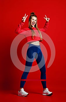 Woman with good physique doing stretching work out with elastic bands.