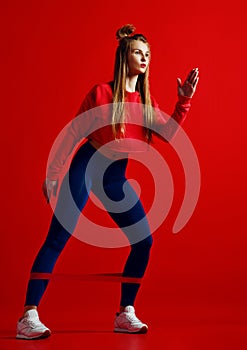 Woman with good physique doing stretching work out with elastic bands.