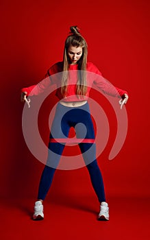 Woman with good physique doing stretching work out with elastic bands.