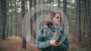 A woman got lost in the woods and checks the map on her smartphone
