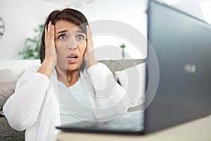 Woman grabbing head following computer malfunction