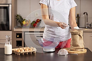 Woman grabbing and measuring flour