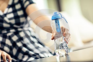 Woman grabs the bottle of filtered water