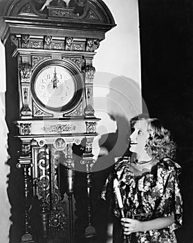 Woman with grandfather clock at midnight