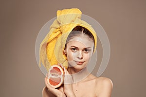 Woman with grapefruit in her hand clean skin bare shoulders spa health treatments