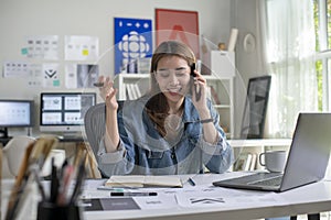 Woman Graphic designer talking on mobile phone while working in office. Artist Creative Designer Illustrator Graphic Skill C