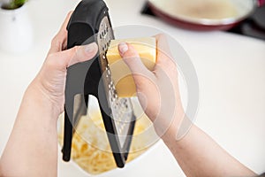 Woman grates cheese on a grater photo