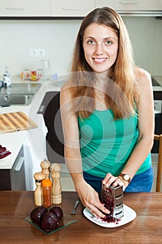 Woman grating boiled beets with grater