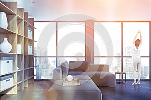 Woman in gray living room with bookcase