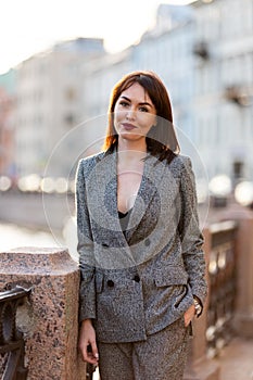 Woman in gray pantsuit walks on promenade