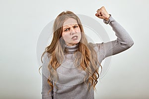 Woman in gray sweater an irritated angry lady shakes her fist in anger