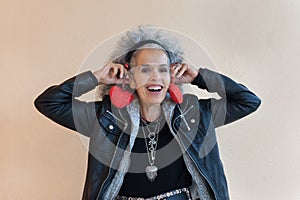 Woman graying hair holding red hearts to her ears