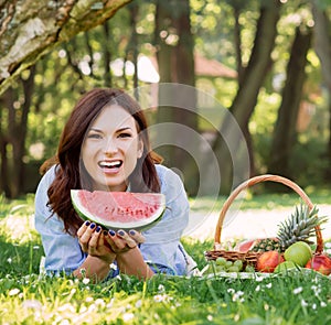 Woman in a great mood having a slice of a watermelon