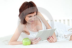 Woman with an green apple and tablet reading ebook