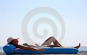 Woman in a green bikini lying on the beach