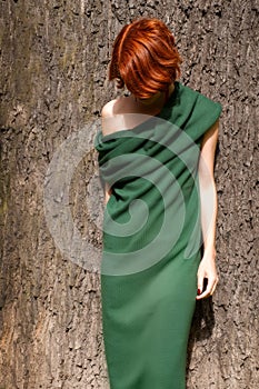 Woman in green dress against giant oak tree