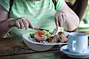 Woman in green dress eating lunch in cafe - image