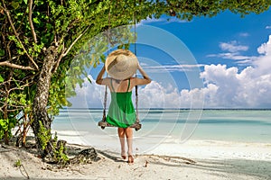 Woman in green dress swinging at beach