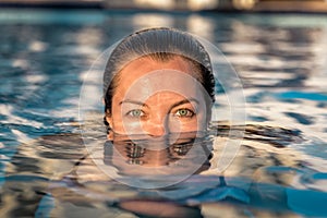 Woman with green eyes in the pool