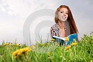 Una mujer sobre el verde a el lee un libro 