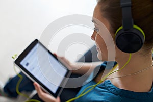 Woman With Green Headphones Listens Podcast Music On Tablet PC