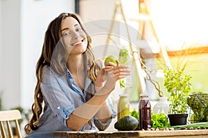 Woman with green healthy food and drinks at home