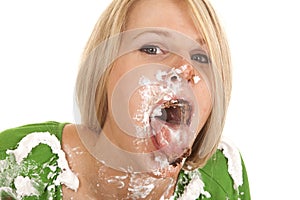 Woman green shirt with whip cream on her face and shirt